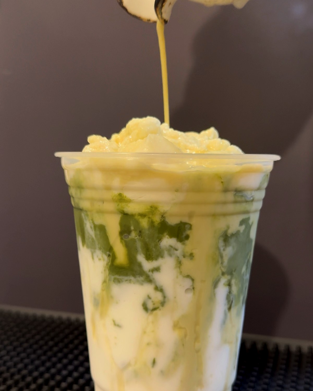 Matcha drink with cream pour